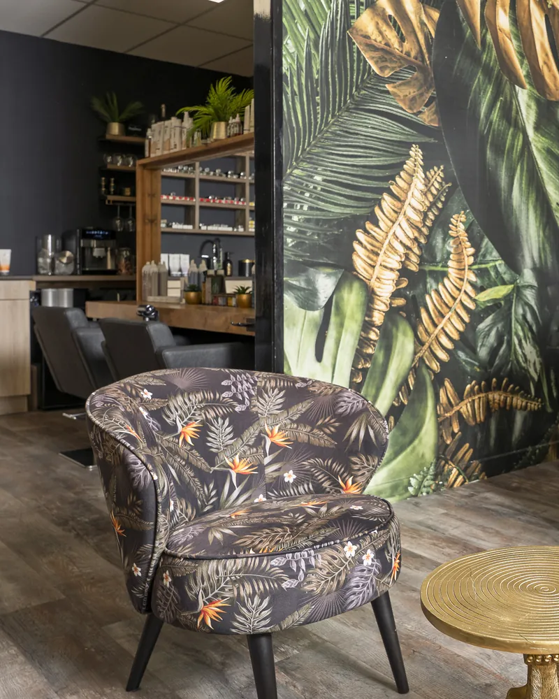 Fauteuil met bloemenprint voor de wand met bladerprint