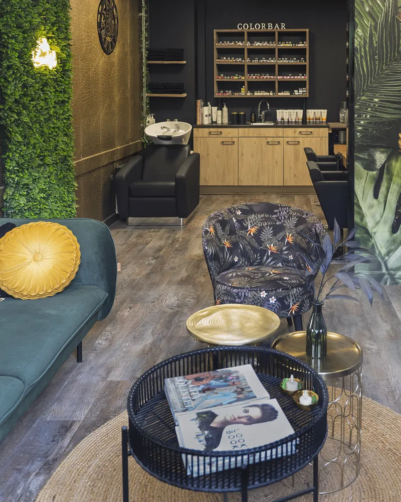 Zithoek met groene bank en fauteuils, met achterin de colorbar